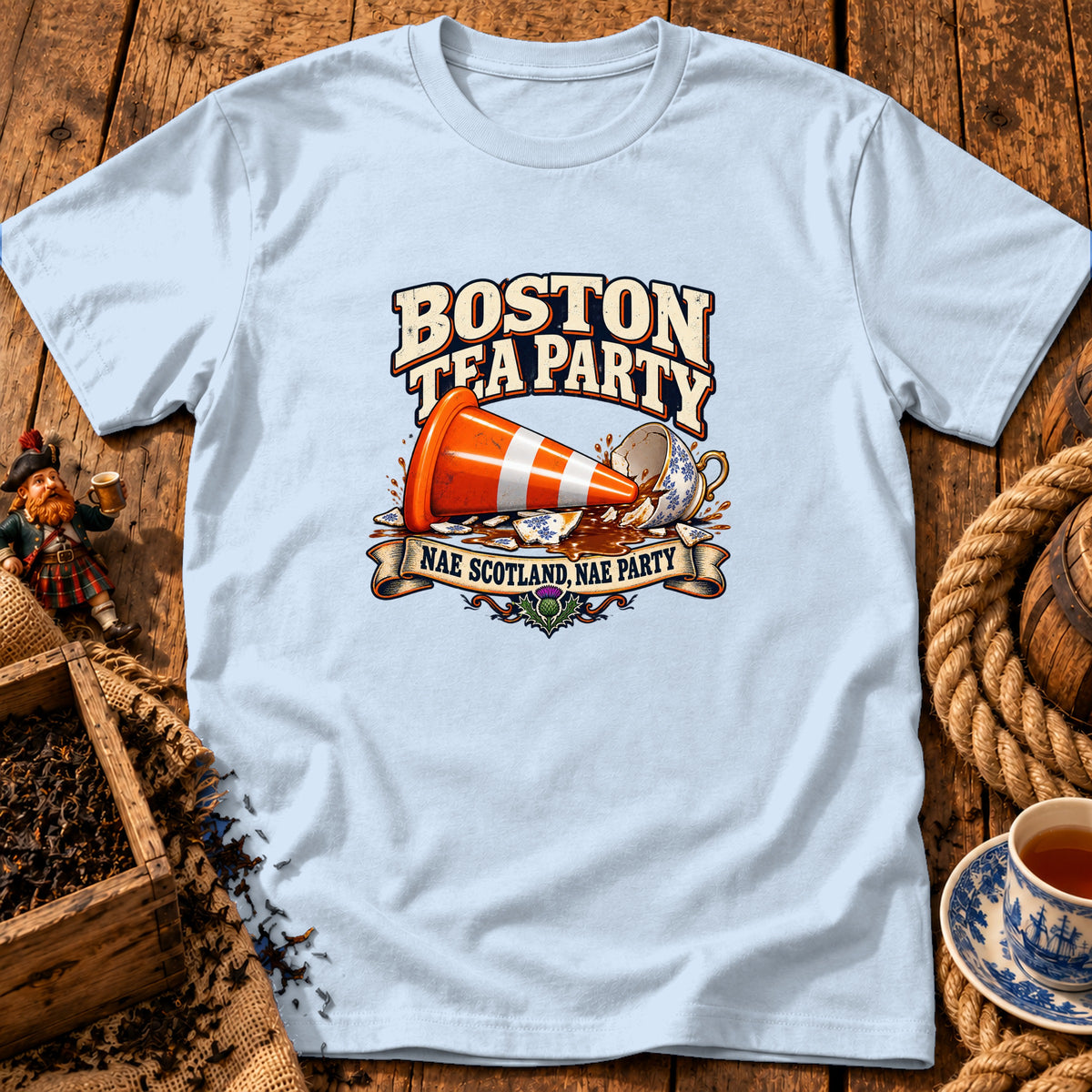 Light blue t-shirt displaying a graphic of a traffic cone inside a broken teacup with Boston Tea Party text.