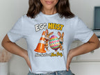 T-shirt graphic: "EGG HEIST" with two cartoon bunnies holding an egg and traffic cone.