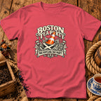 A coral pink t-shirt displays a graphic featuring a teacup, traffic cone, thistles, and text.