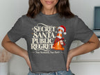 T-shirt with "Secret Santa, Public Regret" and a traffic cone wearing a Santa hat.