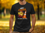Black t-shirt with a chick hatching from a tartan egg, next to an orange cone. Text says "WEE CRACKER Nae Scotland, Nae Party."