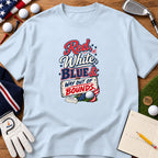 Light blue t-shirt featuring a golf-themed patriotic graphic surrounded by golf equipment on wood.