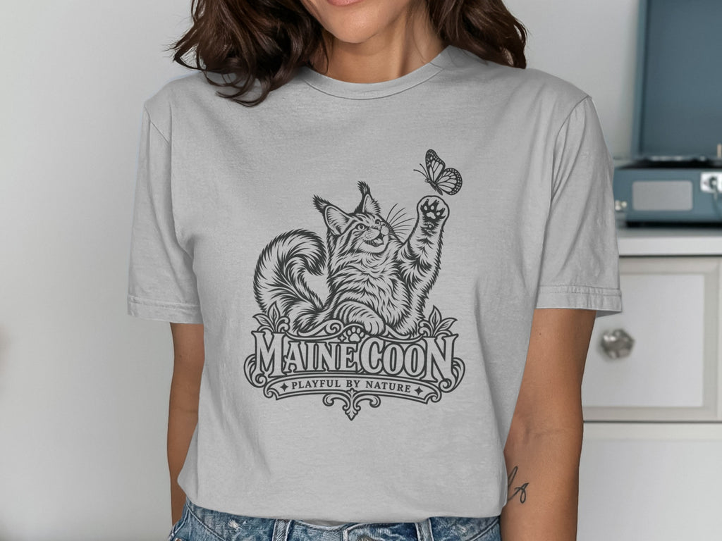 Line art of a Maine Coon cat reaching for a butterfly, with "MAINE COON PLAYFUL BY NATURE" text.