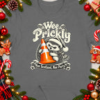 Hedgehog in Santa hat holding traffic cone, with text "Wee Prickly Nae Scotland, Nae Party."