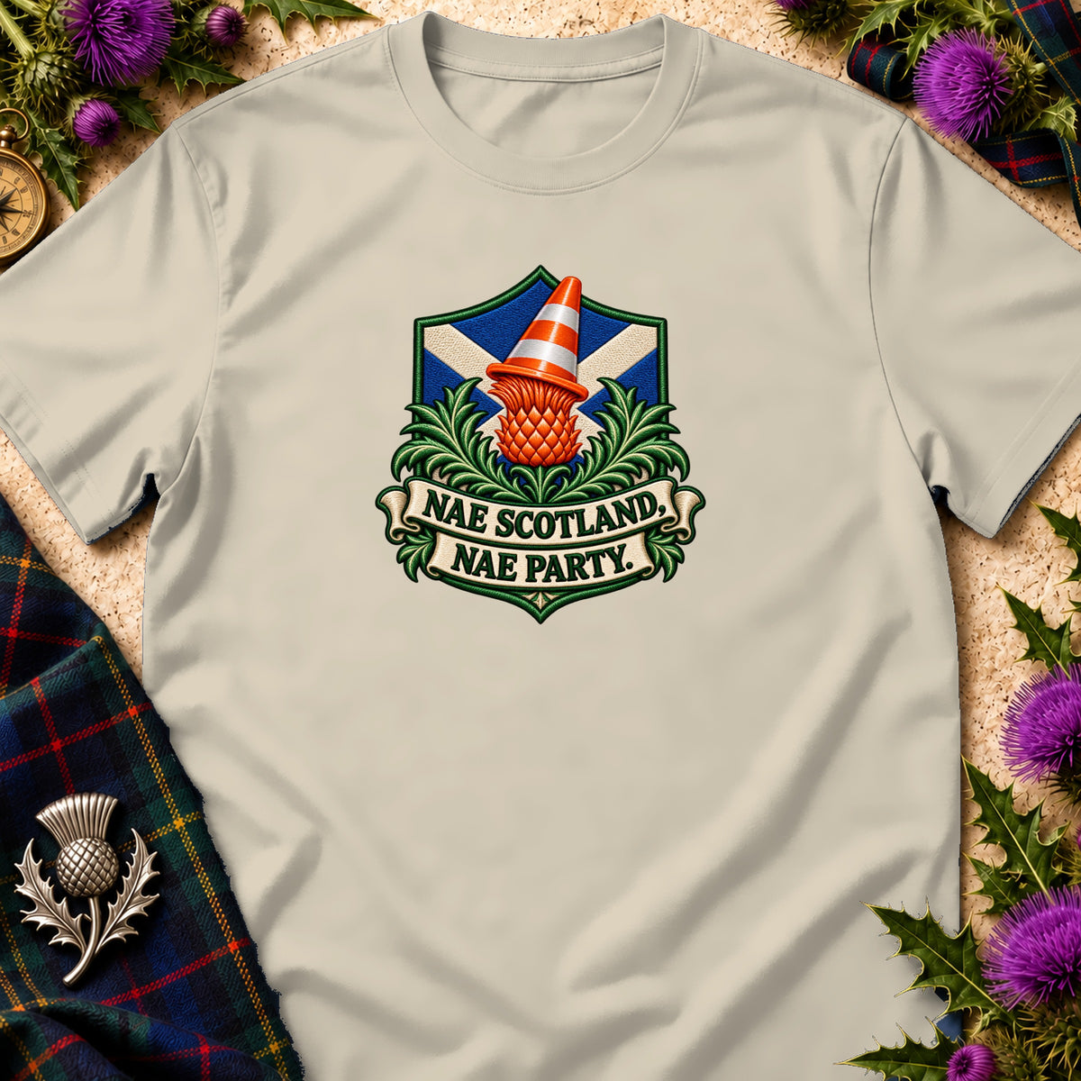 Beige t-shirt featuring a crest with a Scottish flag, thistle, traffic cone, and text reading "NAE SCOTLAND, NAE PARTY."