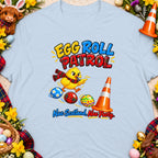 Yellow chick with whistle and tartan scarf, "Egg Roll Patrol" text, Easter eggs, traffic cone.