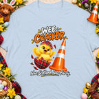 Chick hatching from a tartan egg, "Wee Cracker" text, and traffic cone.