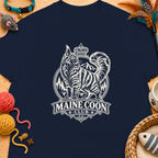 Navy t-shirt with a graphic of a Maine Coon cat wearing a crown above mountains and trees.