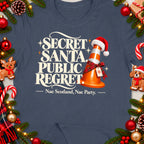 "Secret Santa. Public Regret. Nae Scotland, Nae Party." text on a blue t-shirt with festive decor.