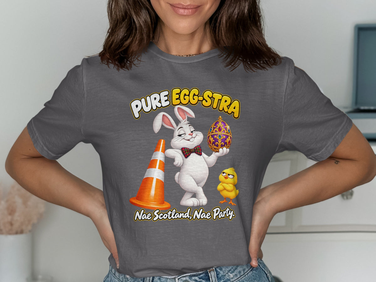 T-shirt graphic with text "PURE EGG-STRA" featuring a rabbit, chick, traffic cone, and ornate egg.