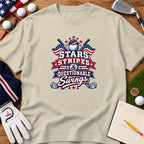 Beige t-shirt featuring a graphic with golf and patriotic elements, surrounded by golf balls, a glove, and a scorecard.