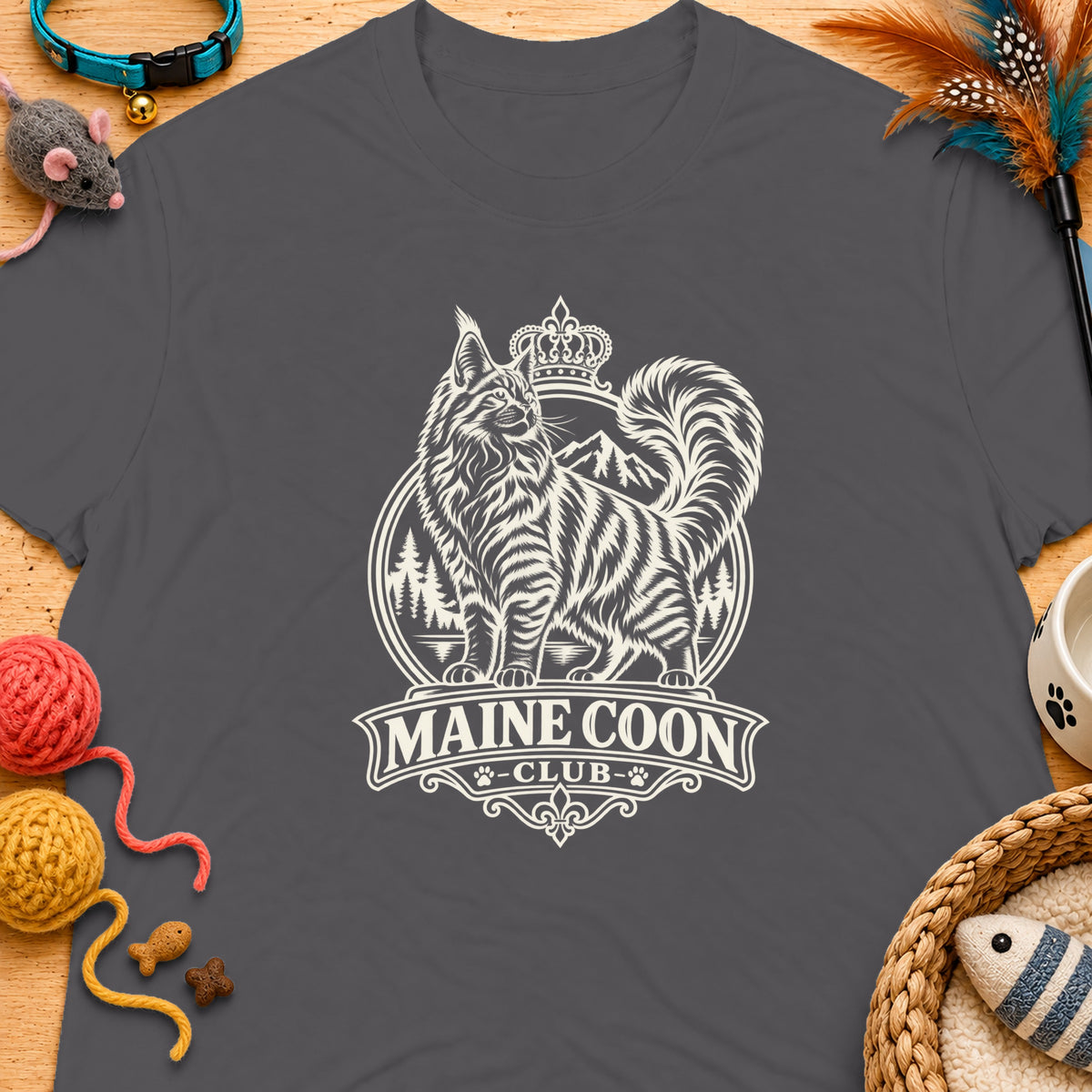 Grey t-shirt with a cream graphic of a Maine Coon cat, mountains, and text "MAINE COON CLUB".