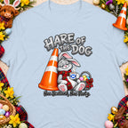Cartoon bunny in kilt scarf holding Scottish flag mug near traffic cone and Easter eggs.
