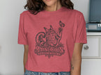 T-shirt with a black graphic of a Maine Coon cat playing with a butterfly, with text.