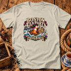 Beige t-shirt featuring a graphic with a traffic cone on a boat and text reading Boston Tea Party and Nae Scotland, Nae Party.