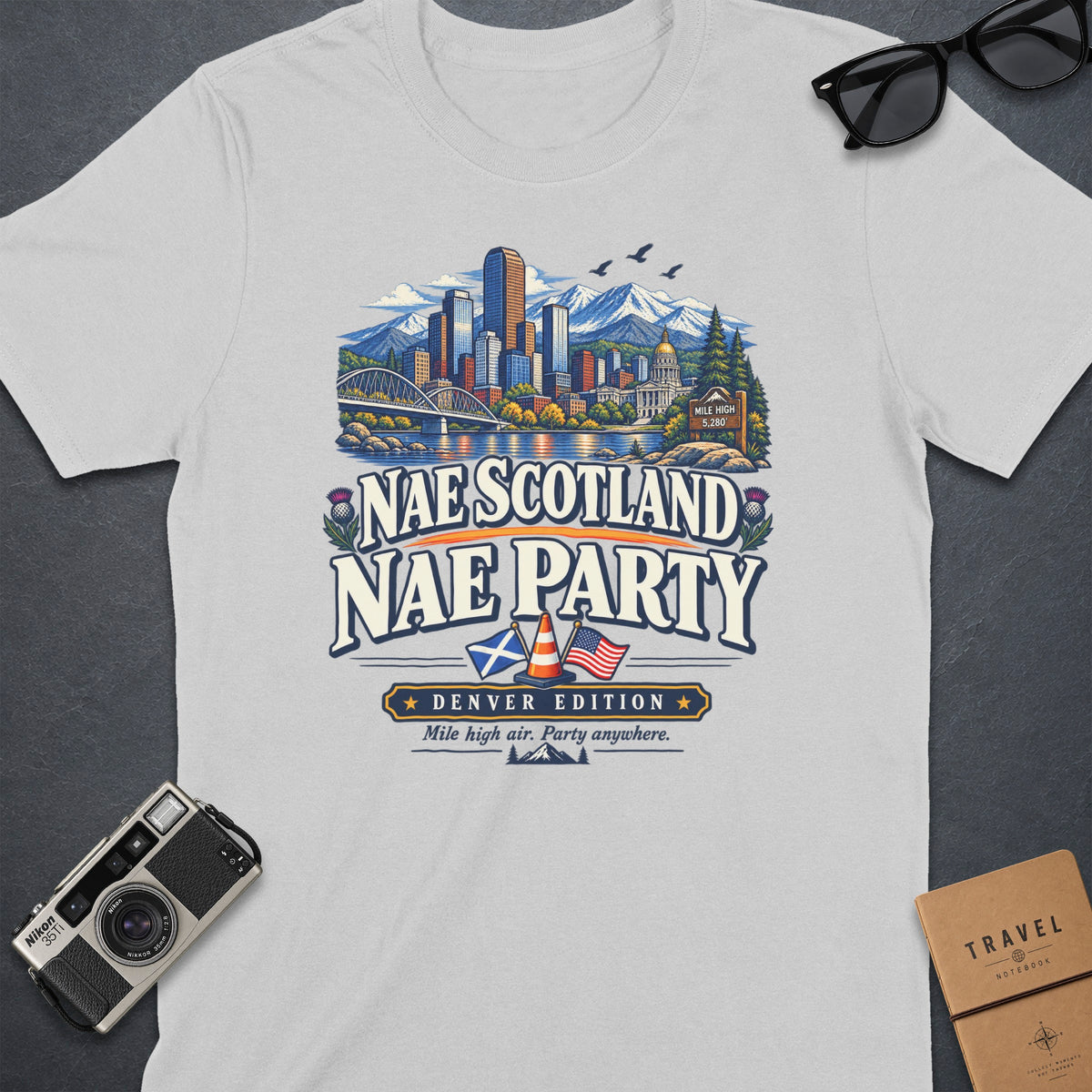 White t-shirt graphic "Nae Scotland Nae Party Denver Edition" with city and mountains.