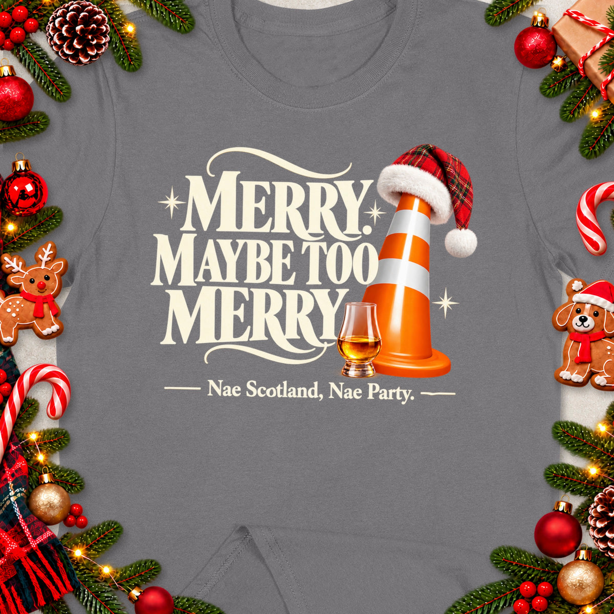 Grey t-shirt with "Merry Maybe Too Merry" text, traffic cone with Santa hat, whiskey glass, and holiday decorations.