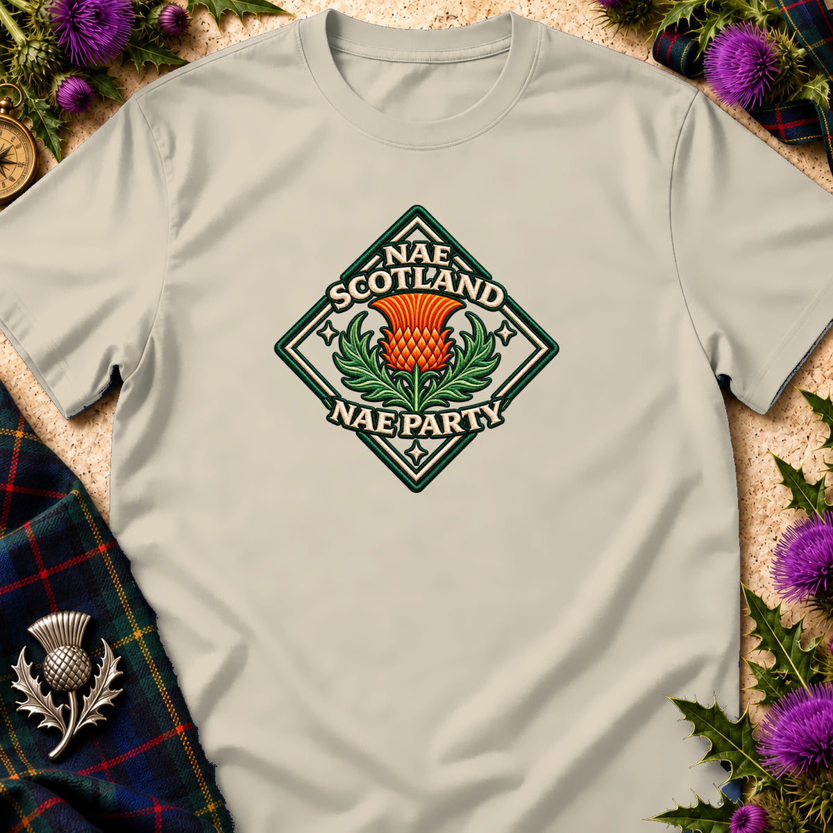 Beige t-shirt featuring a diamond-shaped crest with an orange thistle and the text Nae Scotland Nae Party.