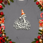 Nessie Noel design on gray t-shirt with holiday decorations and text.