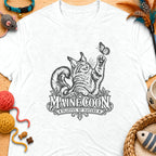 Black and white illustration of a Maine Coon cat reaching for a butterfly, with text "MAINE COON PLAYFUL BY NATURE".