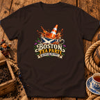 A dark brown t-shirt featuring a graphic with a traffic cone in a Scottish-flag teacup and text reading Boston Tea Party Nae Scotland Nae Party.