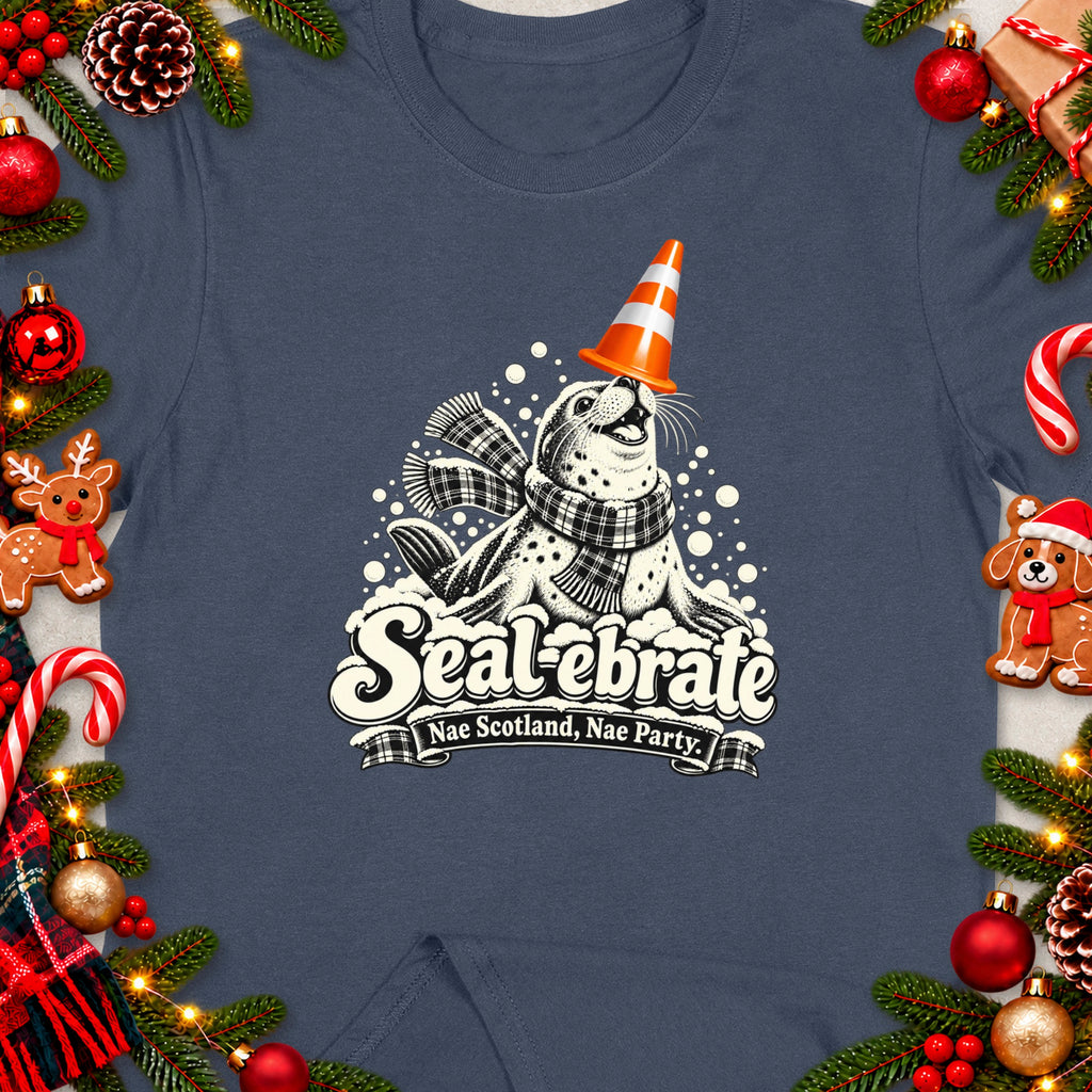 T-shirt graphic with seal wearing party hat, scarf, and text "Sealebrate Nae Scotland, Nae Party".