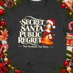 Dark t-shirt with "Secret Santa Public Regret" text and a festive cone.